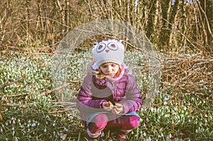 Girl and blossoming white snowdrop photo