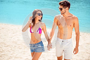 Lovely happy couple in love walking with enjoy on tropical beach with glasses and having fun