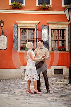 Lovely happy couple. Romantic portrait of married couple in love dancing in an old part of European city. Tenderness and love