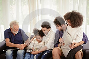 Lovely home family stay together in living room father mother and grandfather playing with daughter mix race