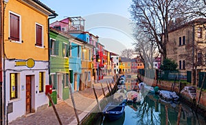 Lovely house facade and colorful walls in Burano, Venice. Burano island canal, colorful houses and boats, Venice landmark, Italy.