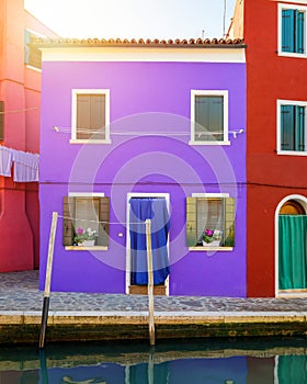 Lovely house facade and colorful walls in Burano, Venice. Burano island canal, colorful houses and boats, Venice landmark, Italy.