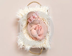 Lovely infant in a flowery hairband, topview photo