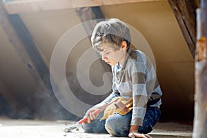 Lovely kid boy helping with toy tools on construction site. Funny child of 6 years having fun on building new family
