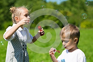 Lovely kids blow bubbles in the park