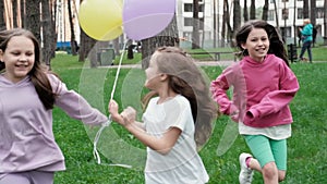 lovely kids girls outdoor with colorful balloons. Happy children running on green grass with balloons in hands. concept
