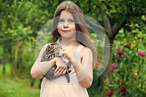 Lovely kitty. small girl hold cute cat in hands. kid love her pet. human and animals. love and care. fluffy kitten in