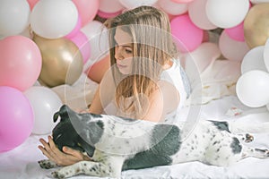 Lovely lady in pajama in bedroom play with her dog. Indoor portrait  girl with baloons in morning. Husband surprising his wife