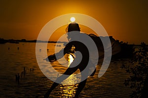 A Lovely Latin Model Is Silhouetted As She Poses With The Rising Sun Behind Her On A Romantic Caribbean Beach