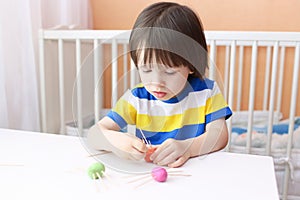 Lovely little boy made toothpick legs by playdough spiders