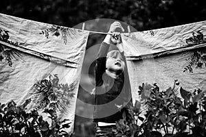 Lovely little five-year girl with clothespin outdoor. Black and white photography.