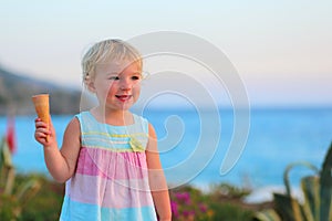 Lovely little girl eating ice cream on the beach
