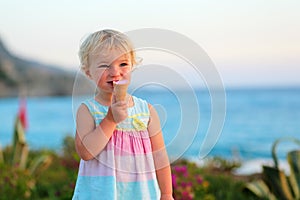 Lovely little girl eating ice cream on the beach