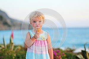 Lovely little girl eating ice cream on the beach