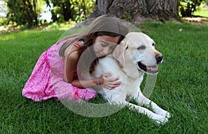 Lovely little girl with her best dog friend at park during summer in Michigan