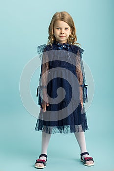 Lovely little girl posing in beautiful blue dress