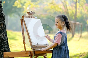 Lovely little girl show happy smile and enjoy with painting in the garden with morning light