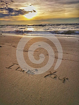 A love message I love you written on the sandy beach.