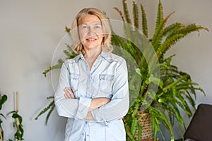 Lovely middle-aged blond woman at home looking at the camera