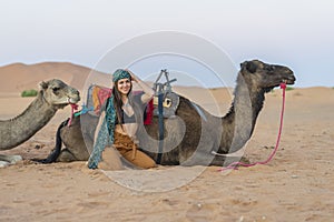 A Lovely Model Rides A Dromedary Camel Through The Saharan Desert On Their Camels In Morocco