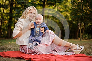 Lovely mother with a baby son on the picnic