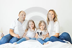 Lovely mother, father, two daughter and little dog pet indoor. Happy family portrait