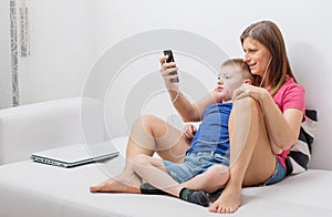 lovely mother and her son listen musing on the sofa