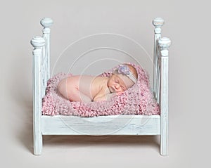 Lovely newborn baby girl sleeps on the crib