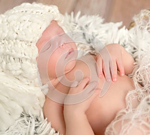 Lovely newborn baby in knitted white hat