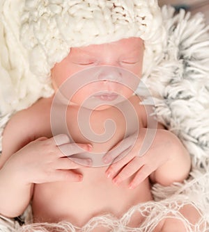 Lovely newborn baby in knitted white hat