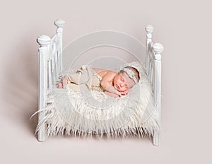 Lovely newborn baby on small crib