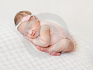 Lovely newborn girl sleeping on pink blanket