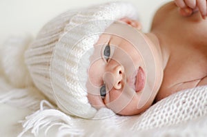 Lovely newborn in white knitted hat