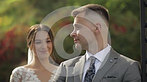 Lovely newlyweds caucasian bride embracing groom in park making kiss, wedding couple family hugging