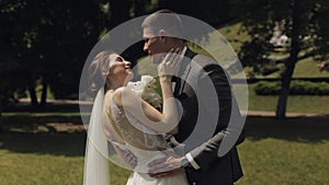 Lovely newlyweds caucasian bride groom dancing in park, making kiss, wedding couple family