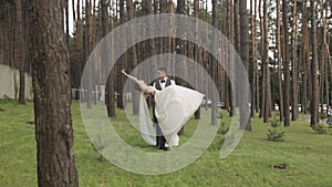 Lovely newlyweds caucasian bride groom dancing in park, making kiss, wedding couple family