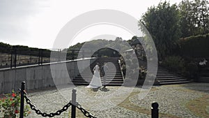 Lovely newlyweds caucasian bride groom walking in park, holding hands, wedding couple family