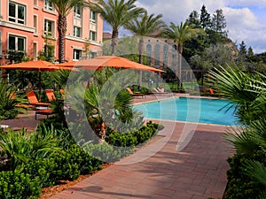 Lovely pool and red umbrellas and chairs in a new apartment complex