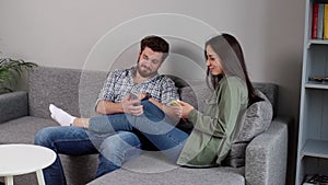Lovely positive young couple are smiling looking at smartphone