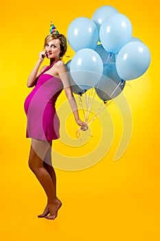 Lovely pregnant young woman with blue balloons