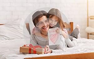 Lovely preschool girl greeting her dad with Father Day