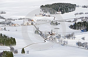 Lovely rural countryside on snowy winter day. Aerial view of barnyards and farm. Weitnau, Allgau, Bavaria, Germany.