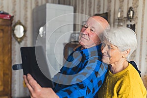 lovely senior couple taking a selfie in the living room medium closeup indoor seniority and technology concept