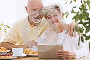 Lovely senior couple using tablet