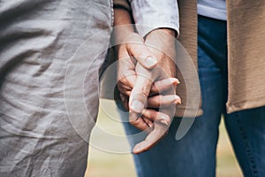 Lovely senior elderly smiling couple man and woman holding hand as promising of forever love or take care in romantic moment. Warm