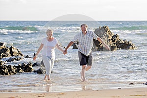 Lovely senior mature couple on their 60s or 70s retired walking happy and relaxed on beach sea shore in romantic aging together