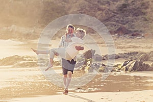 Lovely senior mature couple on their 60s or 70s retired walking happy and relaxed on beach sea shore in romantic aging together