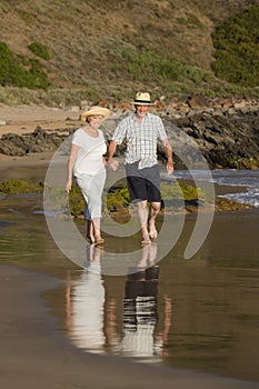 Lovely senior mature couple on their 60s or 70s retired walking happy and relaxed on beach sea shore in romantic aging together