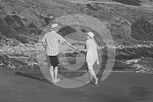 Lovely senior mature couple on their 60s or 70s retired walking happy and relaxed on beach sea shore in romantic aging together