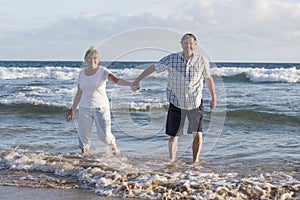 Lovely senior mature couple on their 60s or 70s retired walking happy and relaxed on beach sea shore in romantic aging together